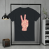 Black t-shirt with red peace sign design on a hanger against a gray wall.