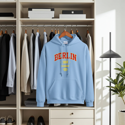 Light blue hoodie with 'BERLIN 1994' text hanging in a wardrobe.