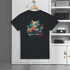 Black t-shirt with a colorful cat graphic on a hanger against a white wall.